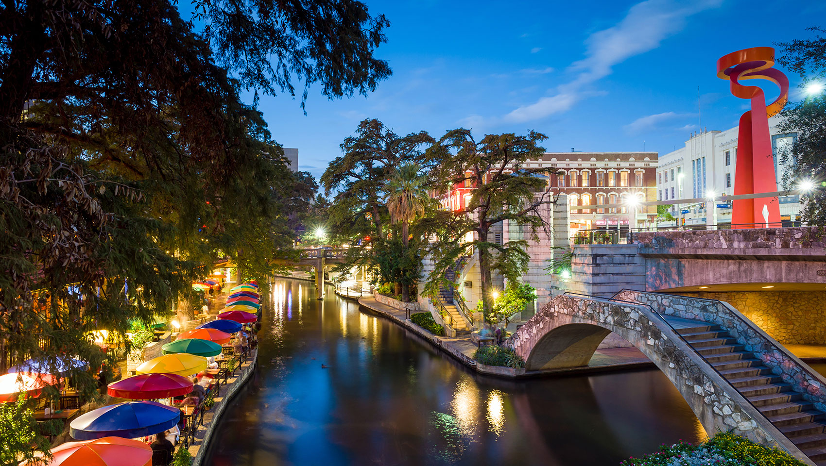 Colorful umbrellas and scenic view along the San Antonio Riverwalk at night